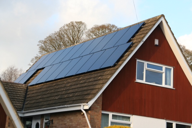 Solar panels installed on a red clad house